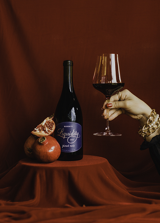 Liquidity Winery Pinot Noir bottle and red wine glass.